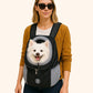 Woman wearing a black/gray mesh pet carrier with a white dog inside 